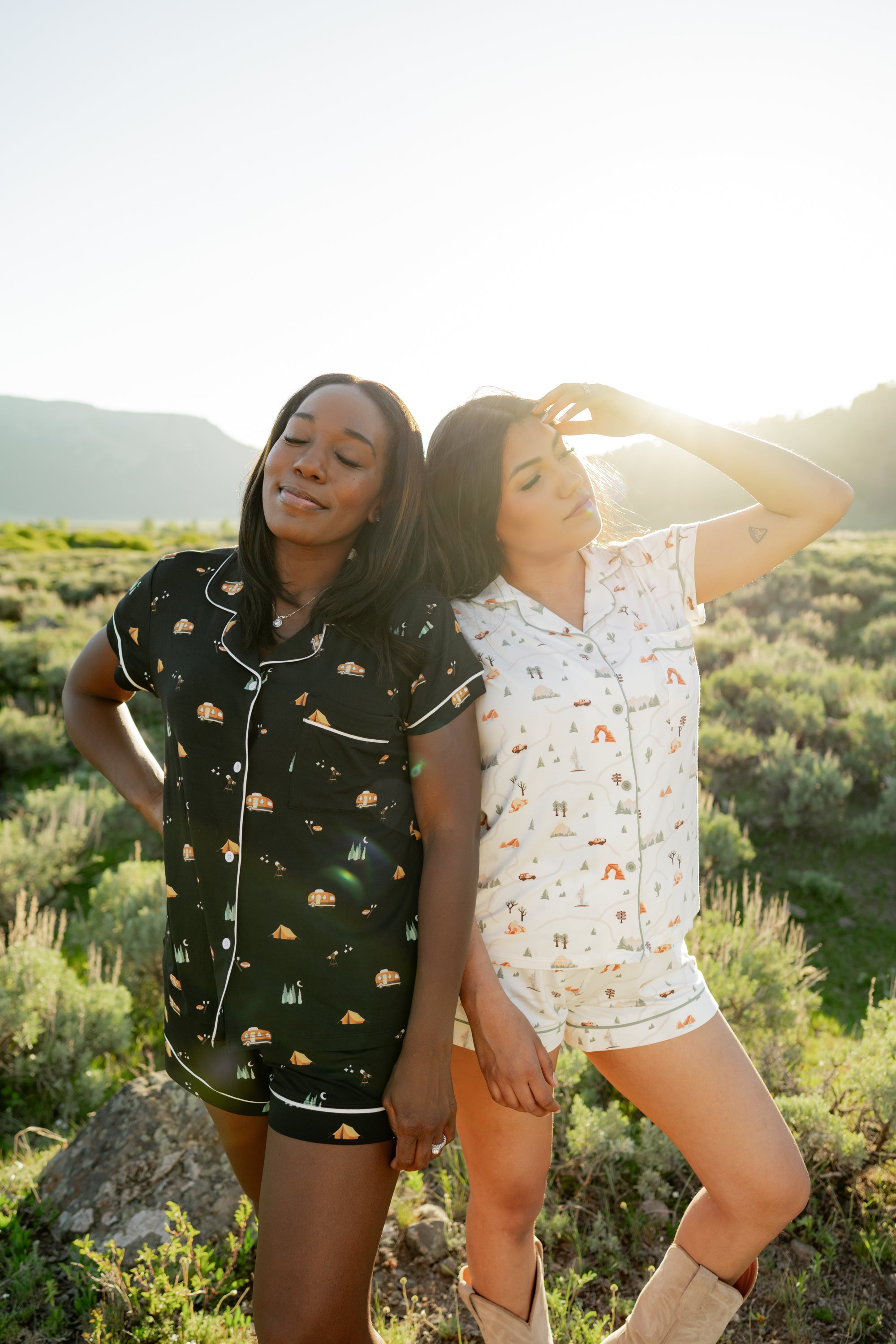 2 women modeling Kyte Living x National Park Foundation collaboration prints. Under the Stars and Road Trip in the Short Sleeve Pajama style.