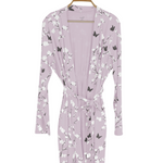 Purple robe with butterfly and floral pattern on a hanger against a white background