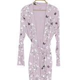 Purple robe with butterfly and floral pattern on a hanger against a white background