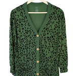 Green bamboo cardigan with leopard print hanging on a hanger 