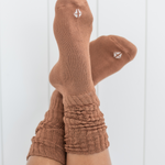 Woman modeling scrunched crew socks in a medium brown color against a white backdrop