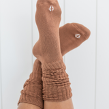 Woman modeling scrunched crew socks in a medium brown color against a white backdrop