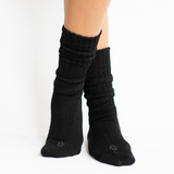 Woman modeling black scrunch socks against white backdrop