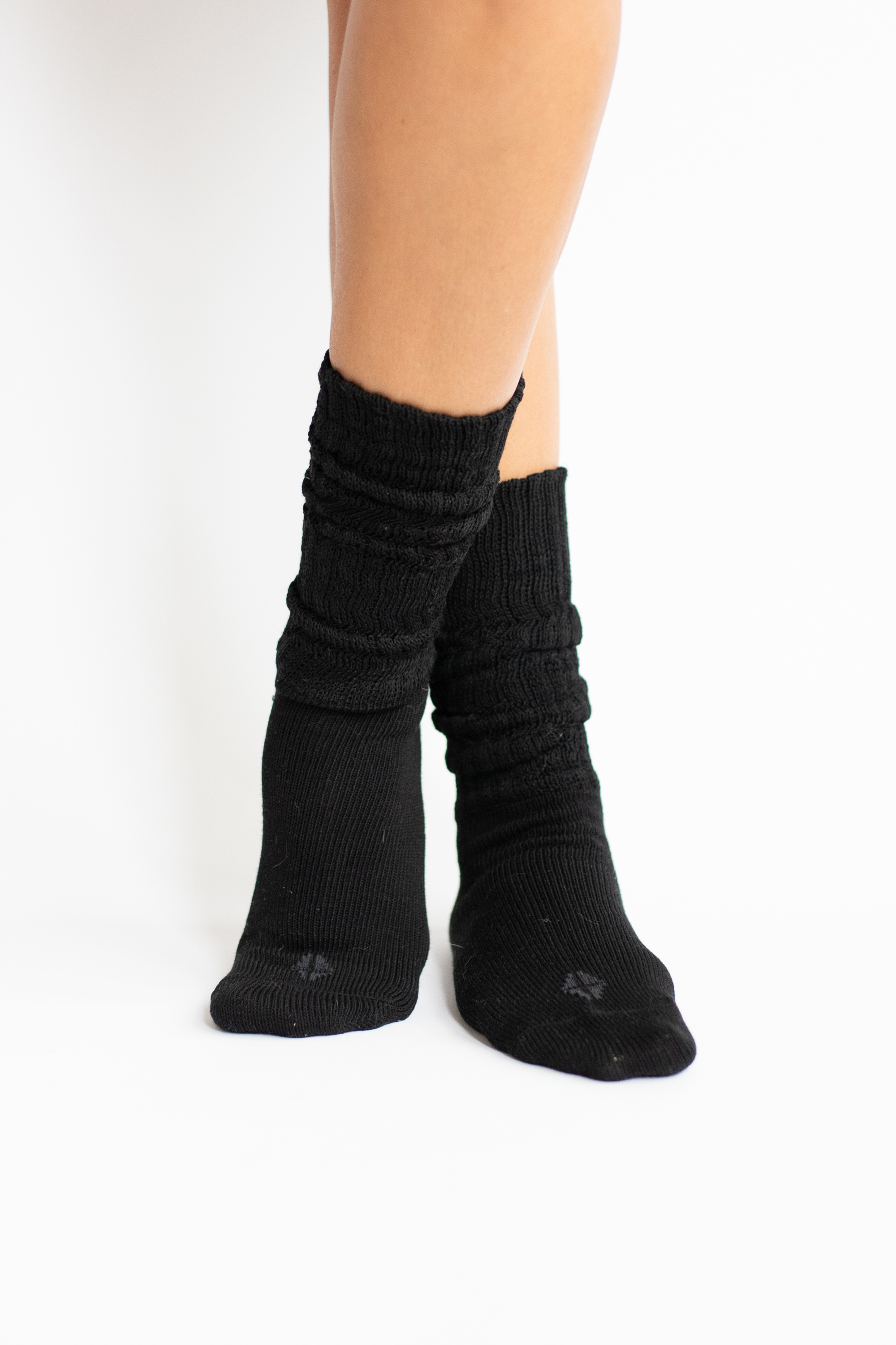Woman modeling black scrunch socks against white backdrop