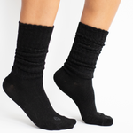 Woman modeling black scrunch socks against white backdrop