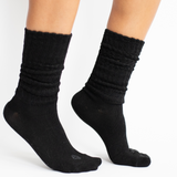 Woman modeling black scrunch socks against white backdrop