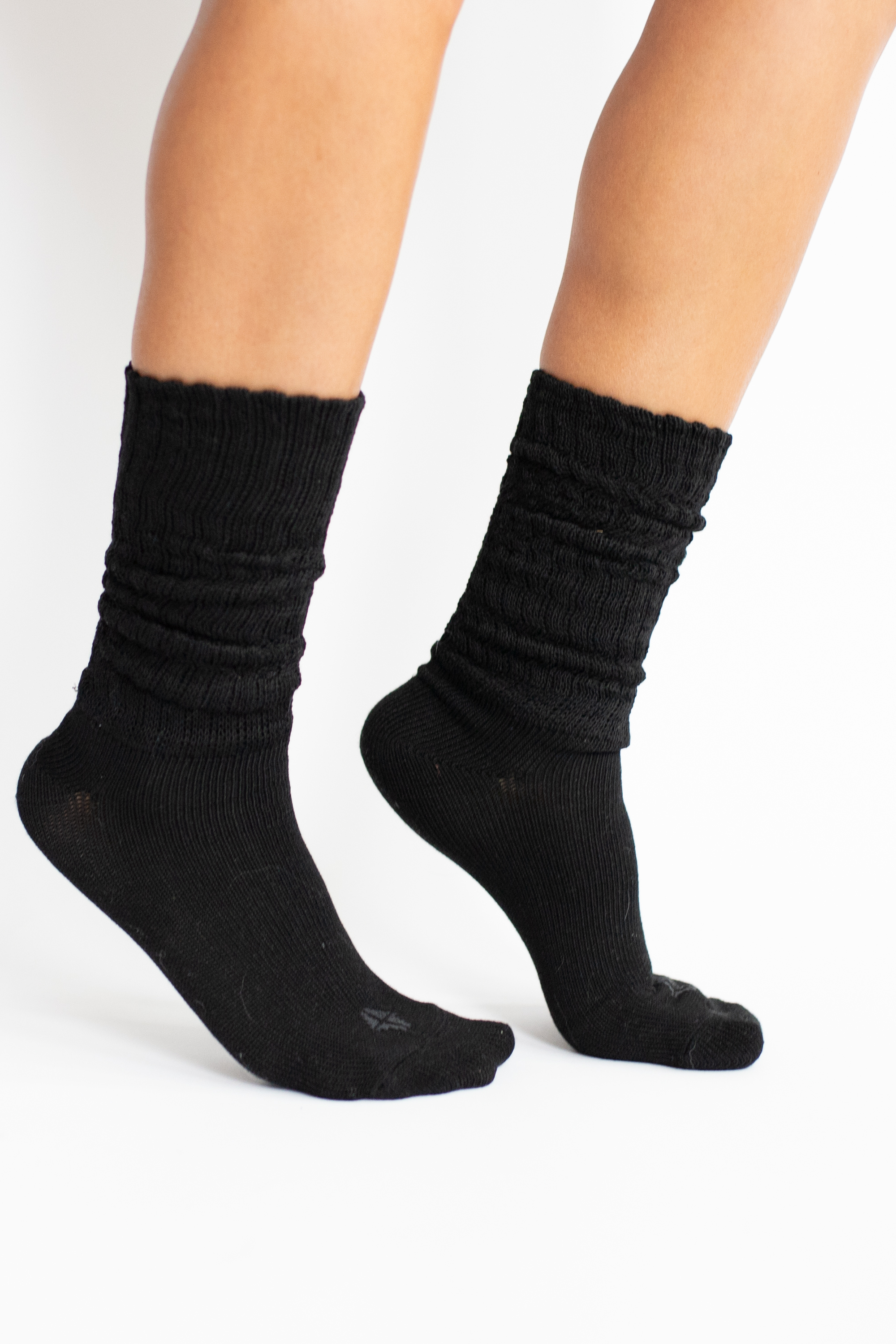 Woman modeling black scrunch socks against white backdrop