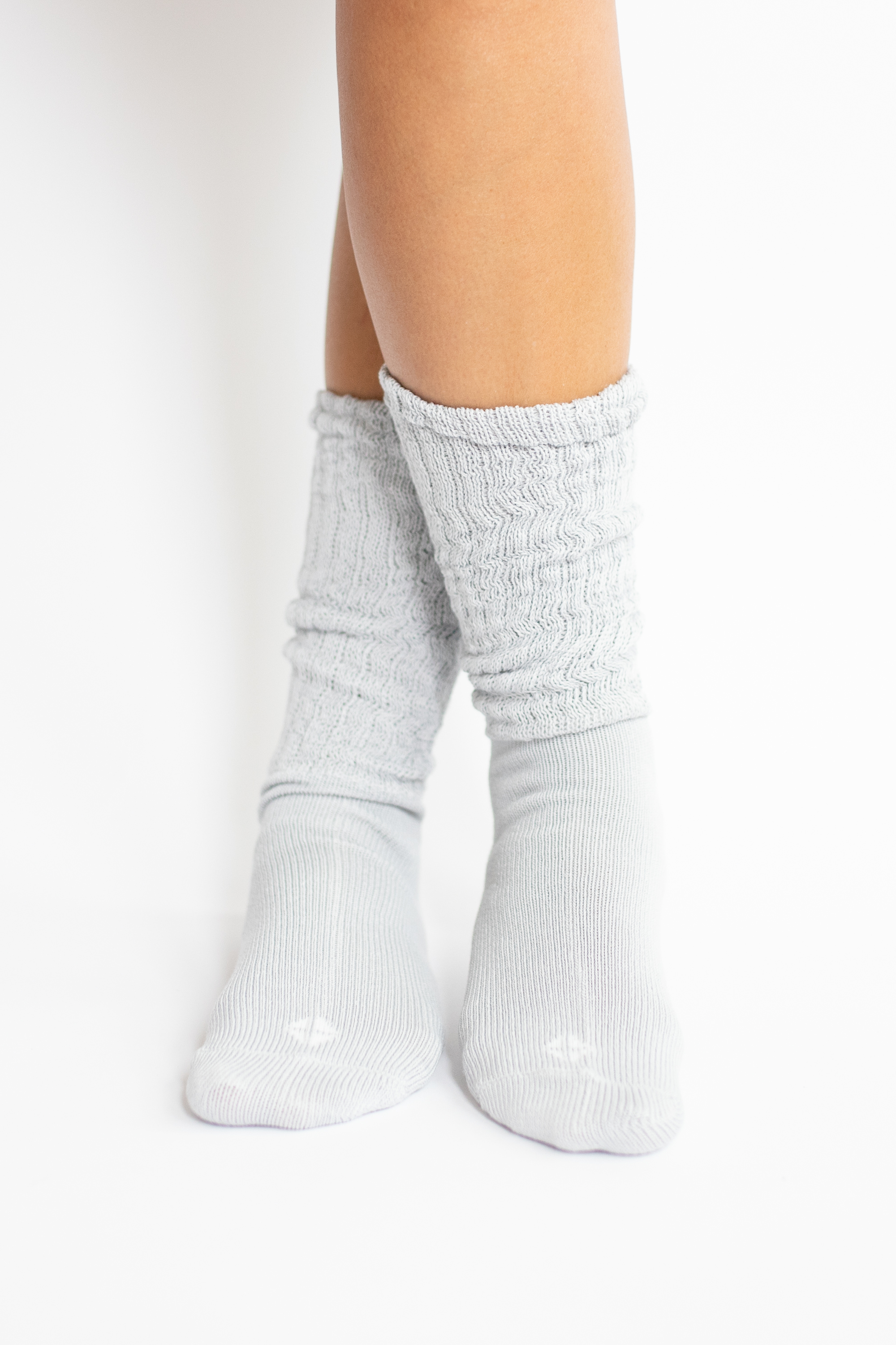 light grey socks worn by a person on a white background