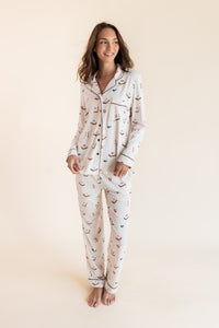 Model wearing Long-Sleeved Women's Pajama Set in Vanilla Mahjong print with brown trim on a beige background