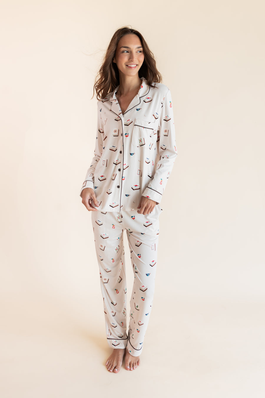 Model wearing Long-Sleeved Women's Pajama Set in Vanilla Mahjong print with brown trim on a beige background