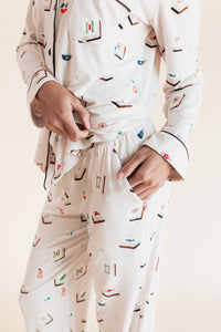 Model showcasing pockets on Long-Sleeved Women's Pajama Set in Vanilla Mahjong print on a beige background
---1605 1