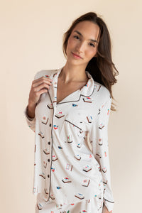 Close up of Model wearing Long-Sleeved Women's Pajama Set in Vanilla Mahjong print with brown trim on a beige background
---PJ 2