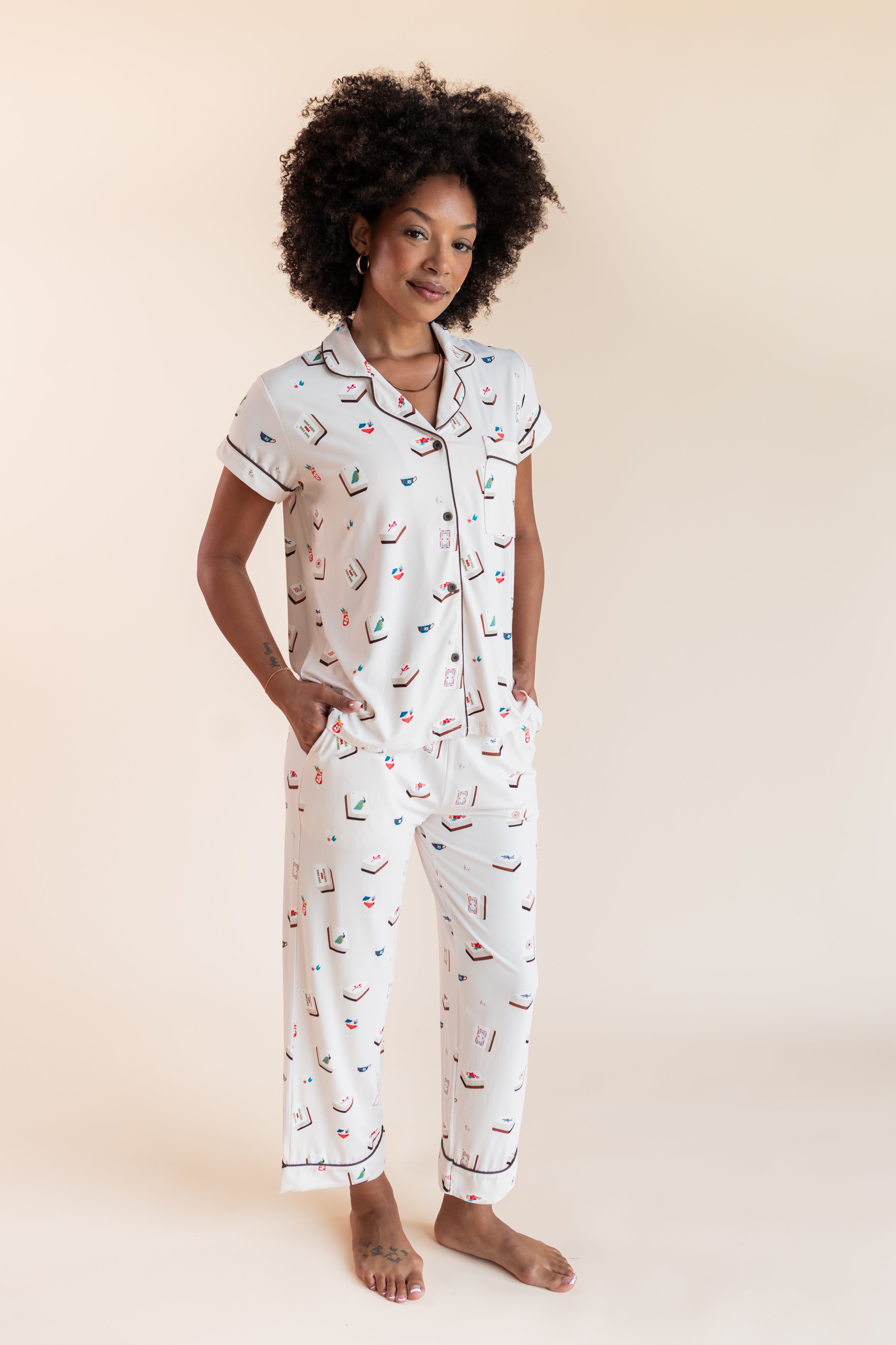Model wearing Women's Short Sleeve Cropped Pajama Set in Vanilla Mahjong print with pockets on a beige background
