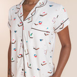 Model wearing Women's Short Sleeve Cropped Pajama Set in Vanilla Mahjong print with brown trim on a beige background
---PJ 2