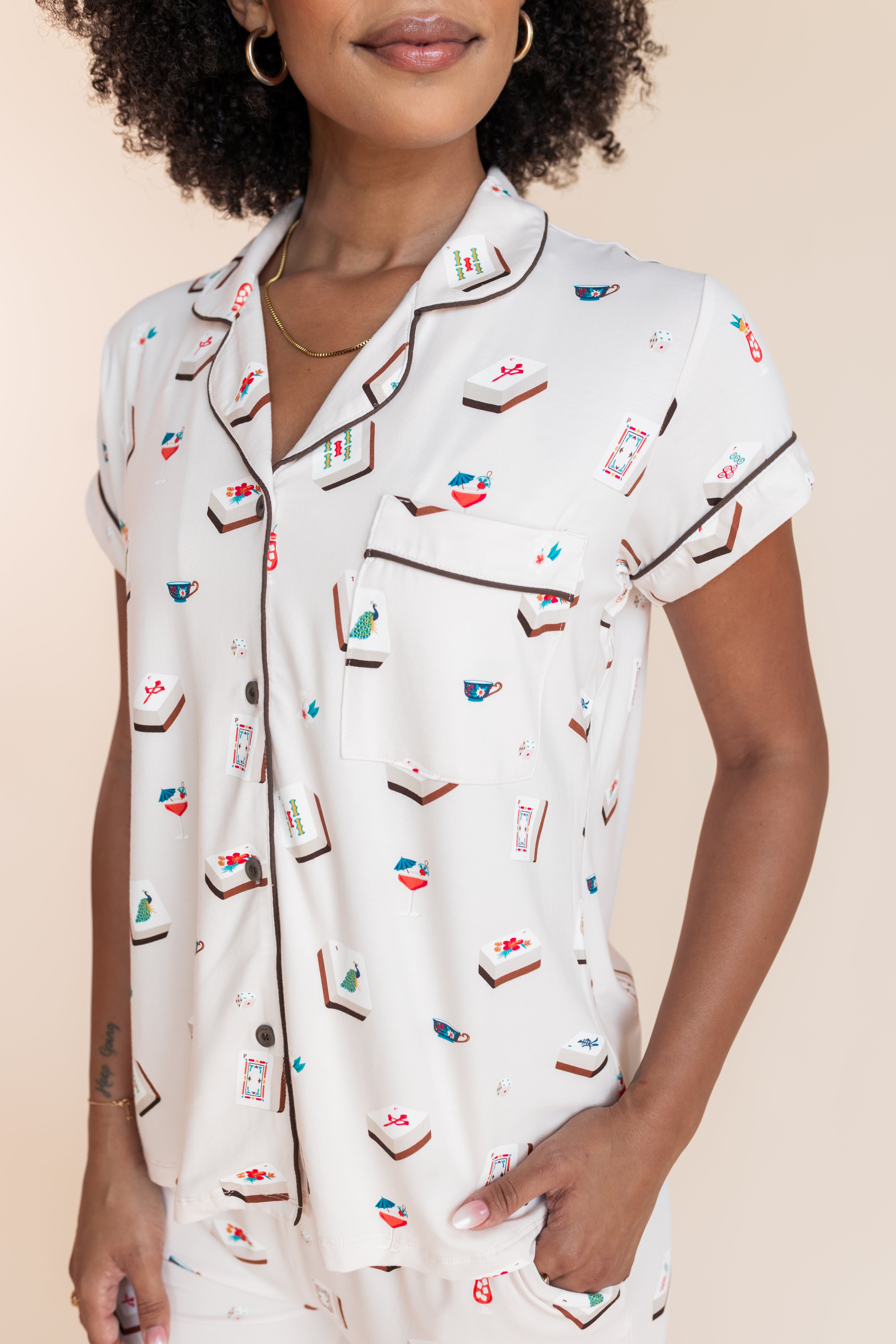 Model wearing Women's Short Sleeve Cropped Pajama Set in Vanilla Mahjong print with brown trim on a beige background
---PJ 2