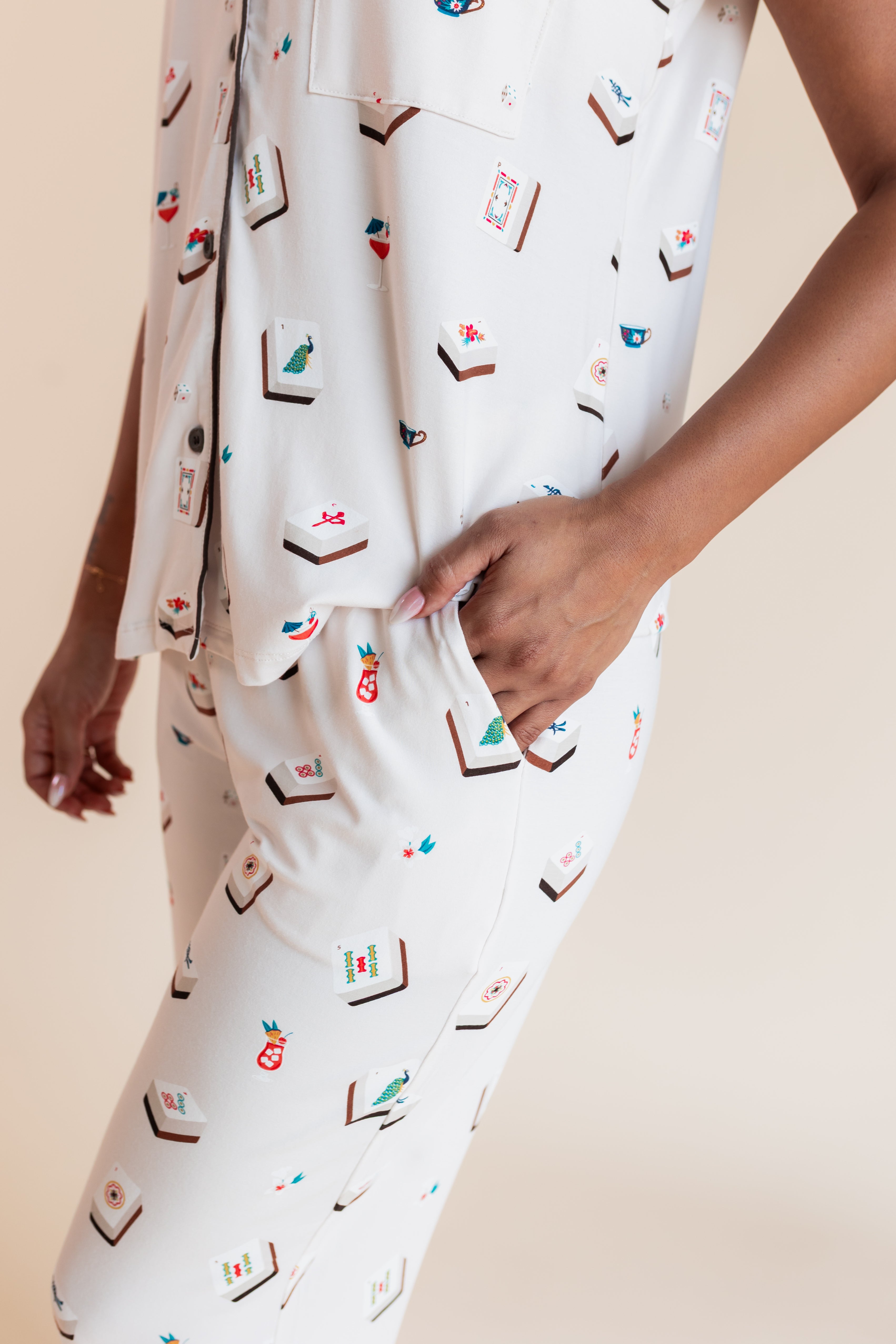 Model showcasing pockets on Women's Short Sleeve Cropped Pajama Set in Vanilla Mahjong print on a beige background