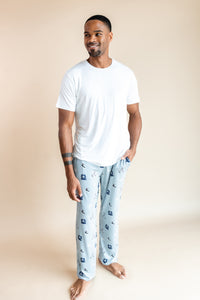 Man posing in Men's Lounge Pants in Vintage Hockey print under white T-shirt on a beige background