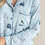 Close up of Modal wearing Long-Sleeved Women's Pajama Set in Vintage Hockey print with pocket and blue trim on a beige background
---PJ 2