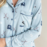 Close up of Modal wearing Long-Sleeved Women's Pajama Set in Vintage Hockey print with pocket and blue trim on a beige background
---PJ 2