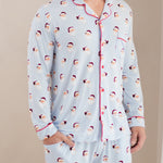 Person wearing a light blue pajama set with Santa Claus pattern on a beige background