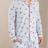 Person wearing a light blue pajama set with Santa Claus pattern on a beige background