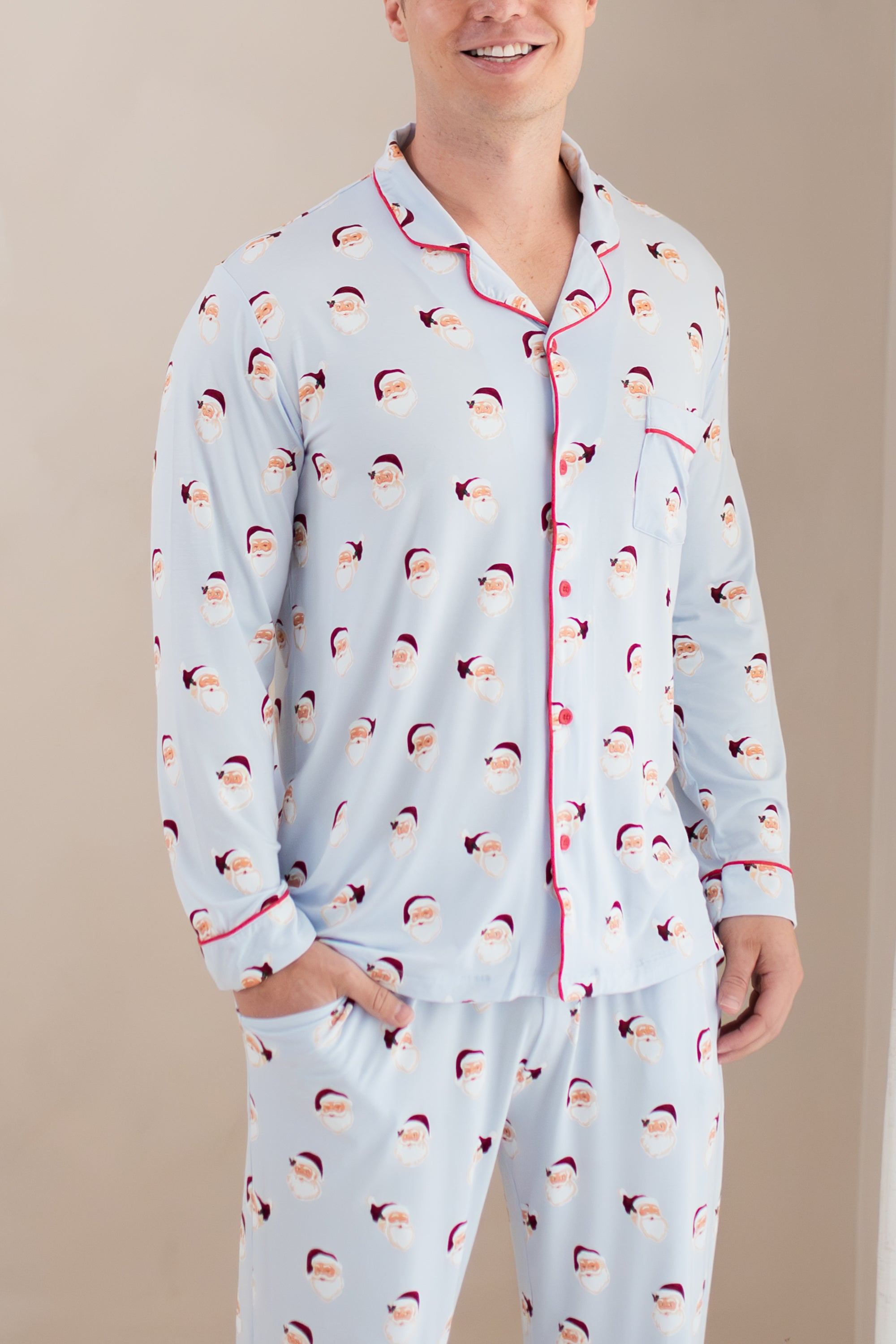Person wearing a light blue pajama set with Santa Claus pattern on a beige background
