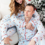 Two people wearing matching pajamas with a Christmas tree in the background