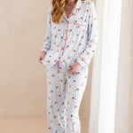 Woman wearing a pajama set with santa pattern on a beige background
