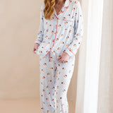 Woman wearing a pajama set with santa pattern on a beige background