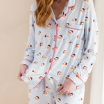 Woman wearing a pajama set with santa pattern on a beige background