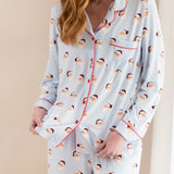 Woman wearing a pajama set with santa pattern on a beige background