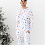 Male model standing beside a frosted tree wearing the Men's Jogger Set in Vintage Santa with his hands in the pants pockets