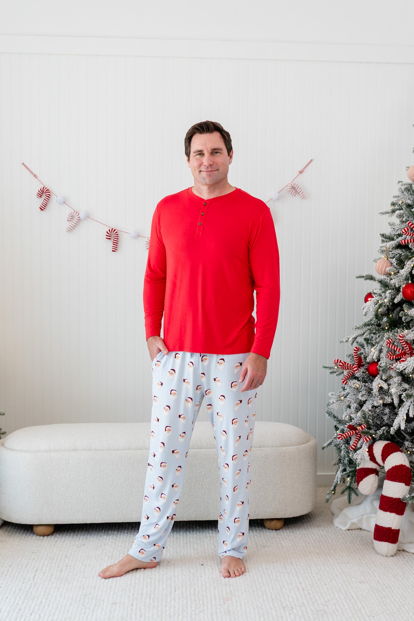 Model waring the Men's Long Sleeve Henley Top in Cardinal paired with the Mens Lounge Pants in Vintage Santa