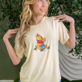 Woman wearing yellow graphic tee with winnie the pooh birthday party graphic ::: Model is 5'7" wearing size S ///
