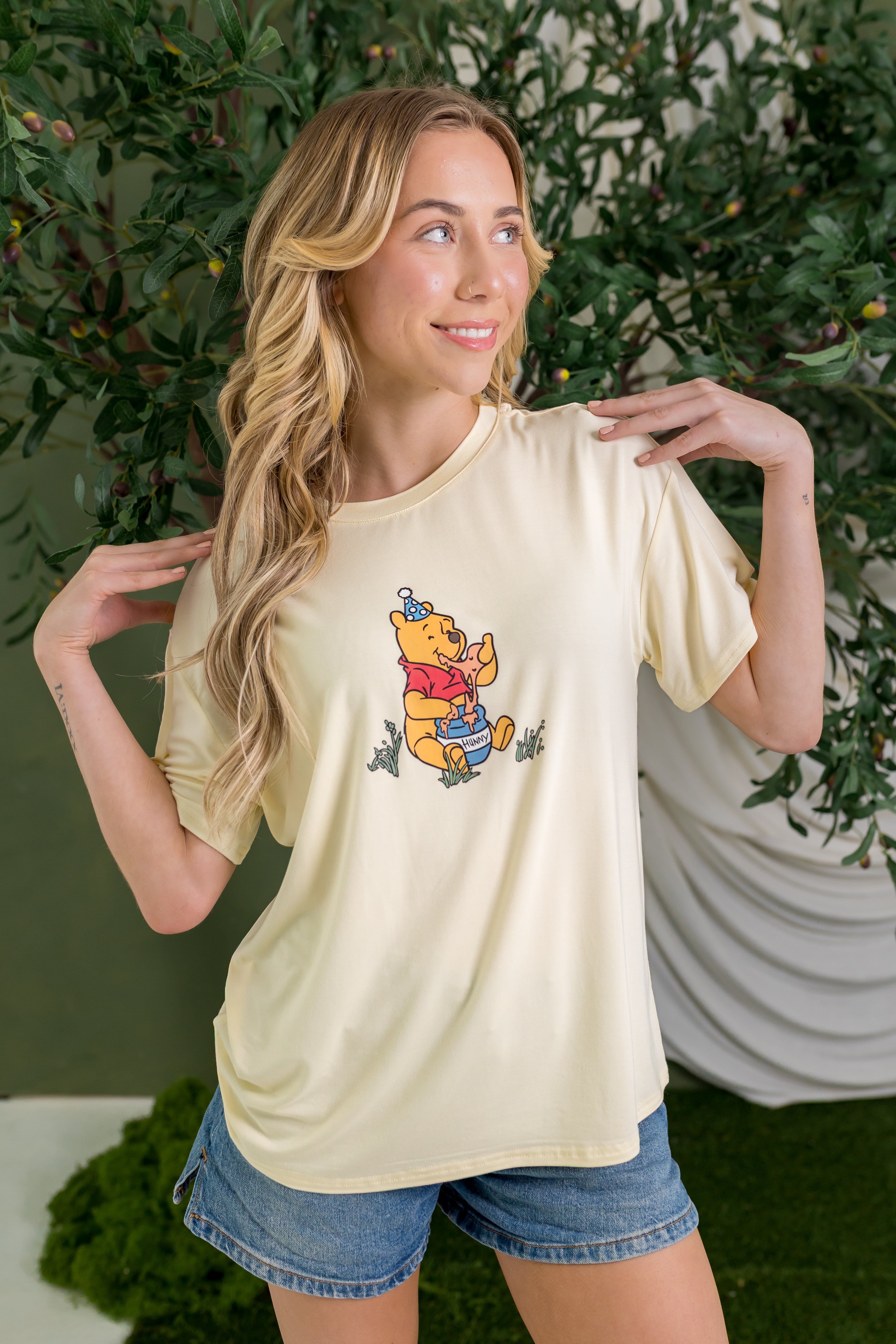 Woman wearing yellow graphic tee with winnie the pooh birthday party graphic ::: Model is 5'7" wearing size S ///