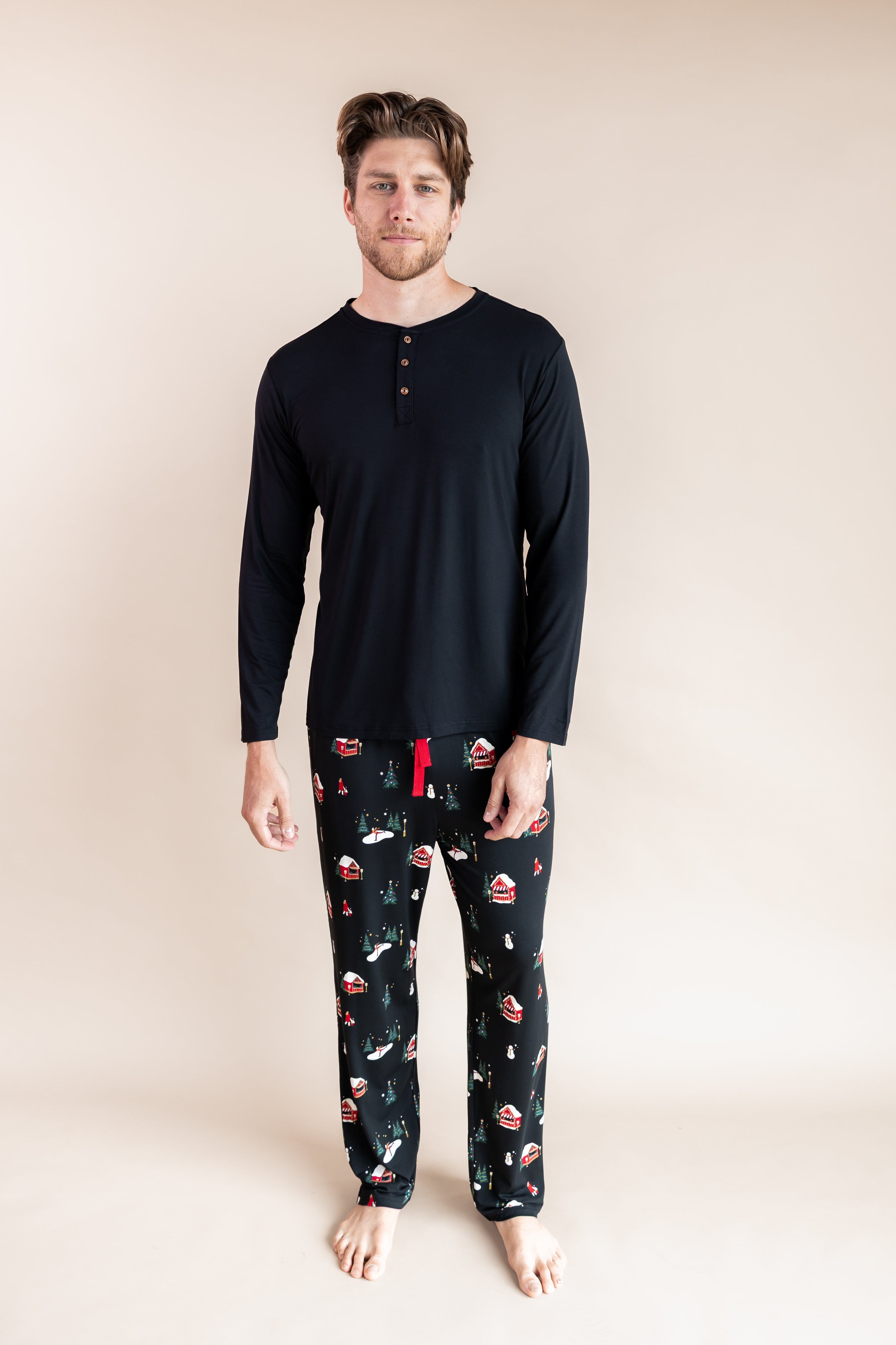 Man standing wearing a long sleeve shirt and lounge pants in winter wonderland
