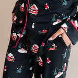 Womans bottom half with her hands in her pocket wearing long sleeve pajama set in winter wonderland