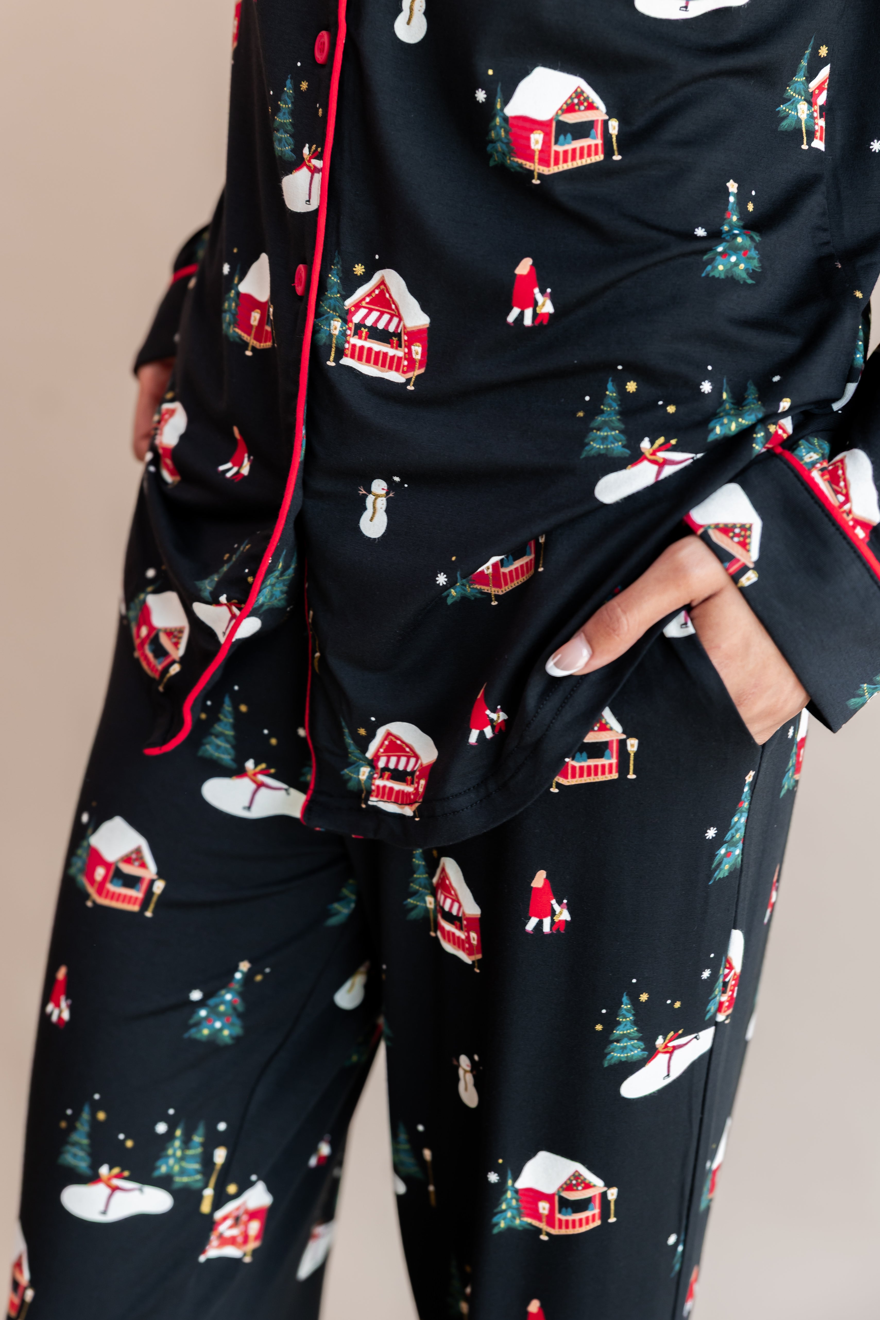 Womans bottom half with her hands in her pocket wearing long sleeve pajama set in winter wonderland