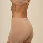 Model showcasing the back side of the Women's Boxer in Chai and the straps of the matching bra