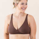 Woman wearing a brown bralette set on a plain background