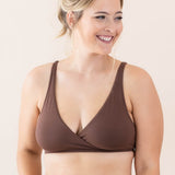 Woman wearing a brown bralette set on a plain background