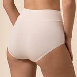 Person wearing cream high-waisted underwear on a beige background