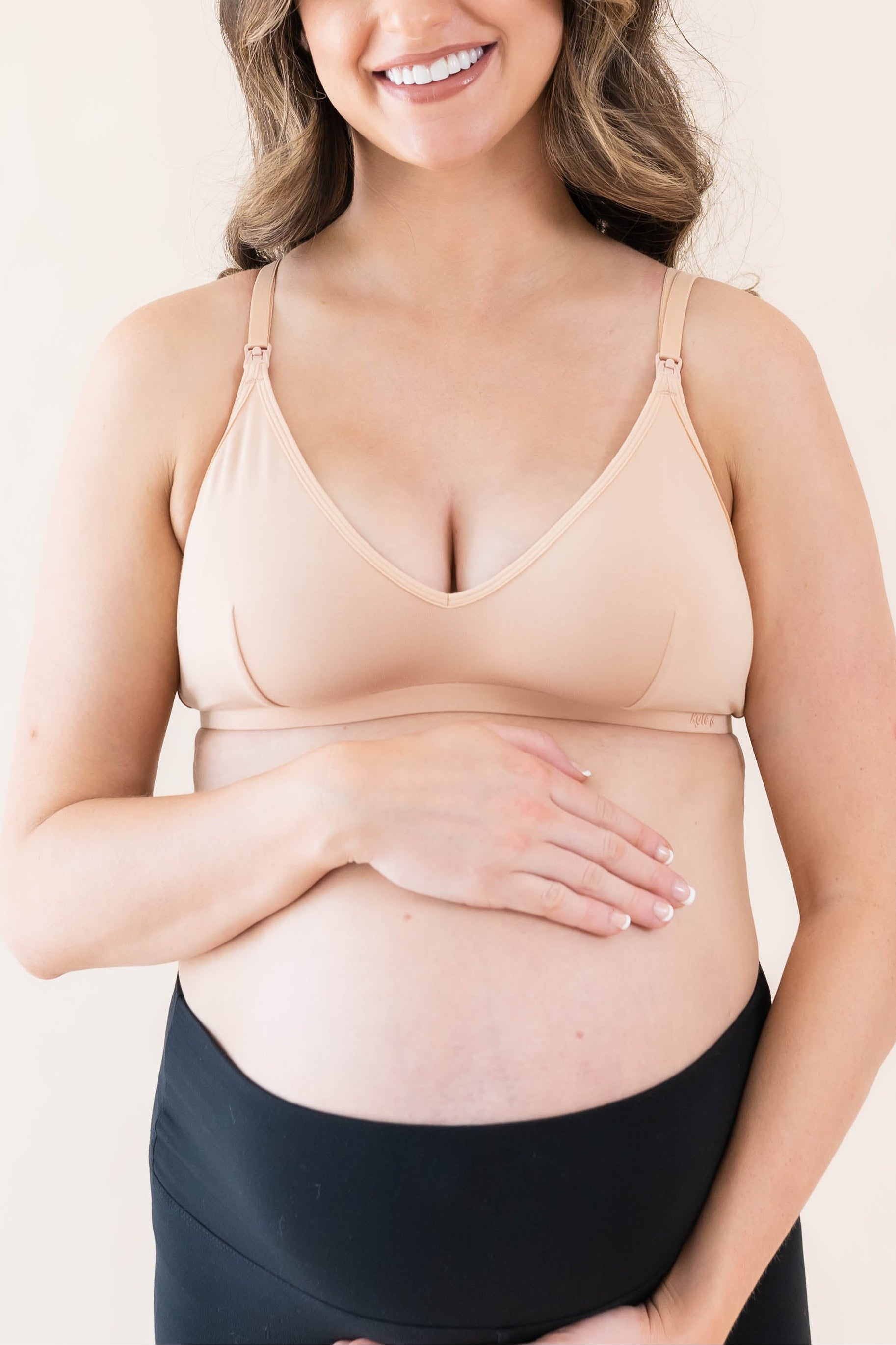 Pregnant woman wearing Kyte Baby's Women's Nursing Bra in Chai