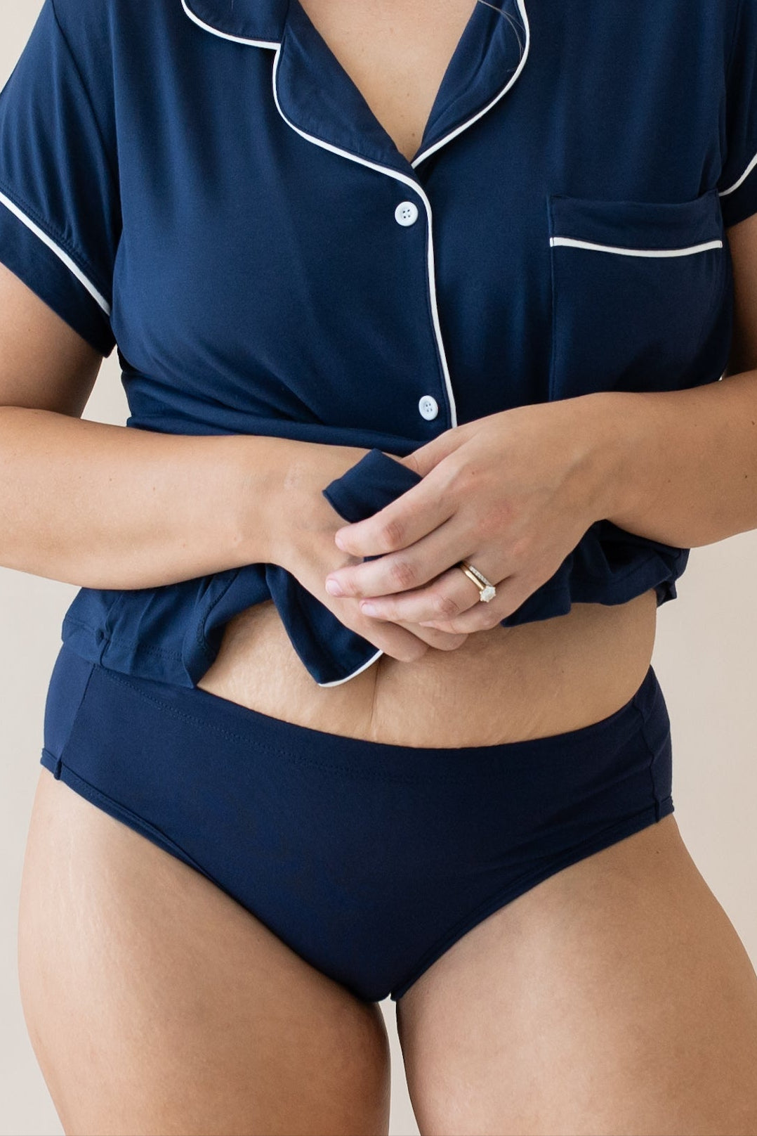Woman wearing navy underwear and a navy button up pj top
