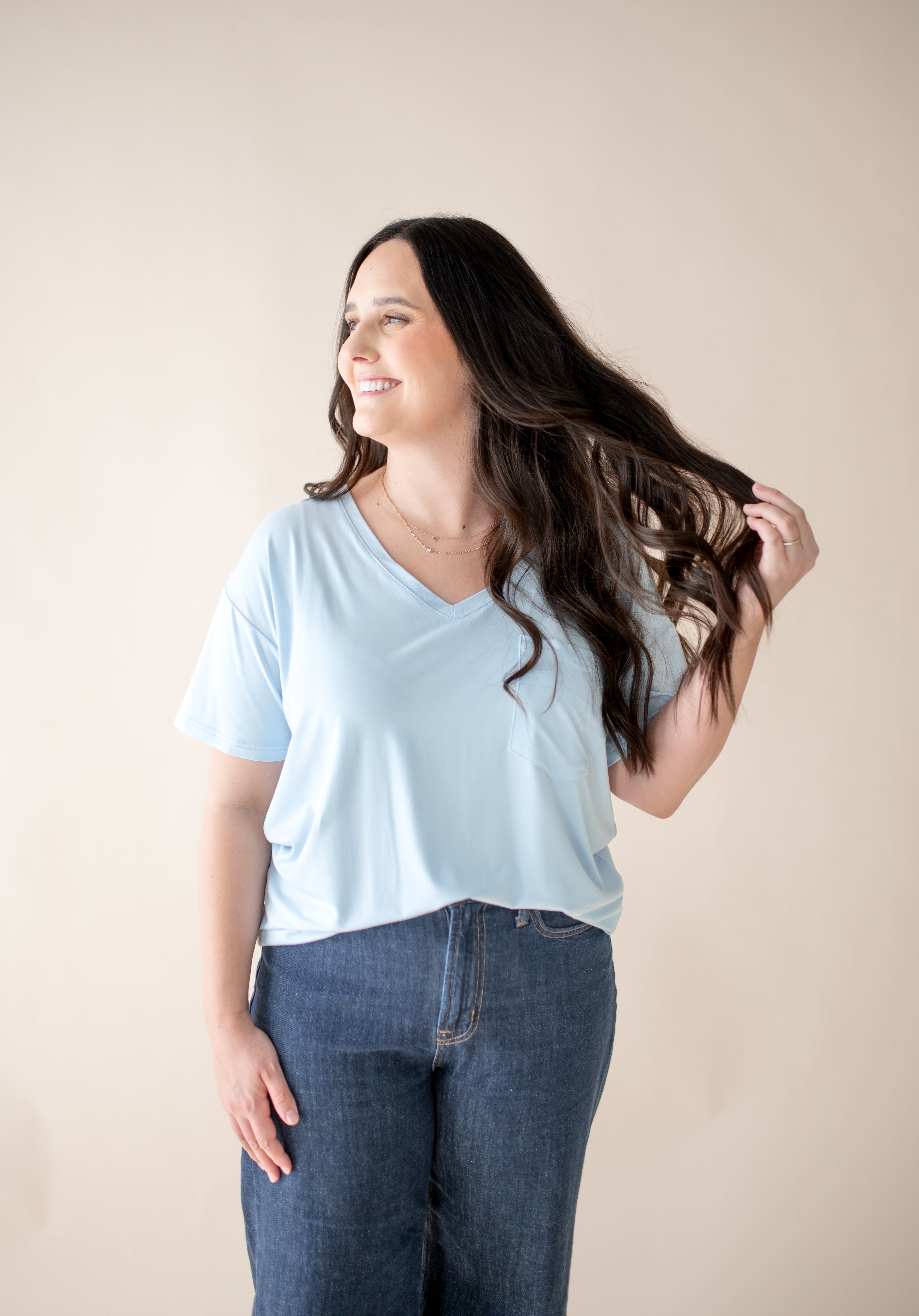 Smiling model looking to the side while wearing the Women's V Neck in Breeze denim ::: Model is 5'6" wearing size M ///
