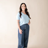 Model  wearing the Women's V Neck in Breeze paired with dark wide leg denim