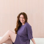 Female model sitting wearing the Women’s Biker Short Set in Currant