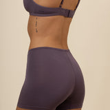 Model showcasing back side of women's Women's Boxer in Currant and back straps of matching bra 