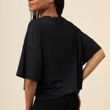 Back side of model wearing the Women's Boxer in Midnight and matching Tee with one hand on hip 