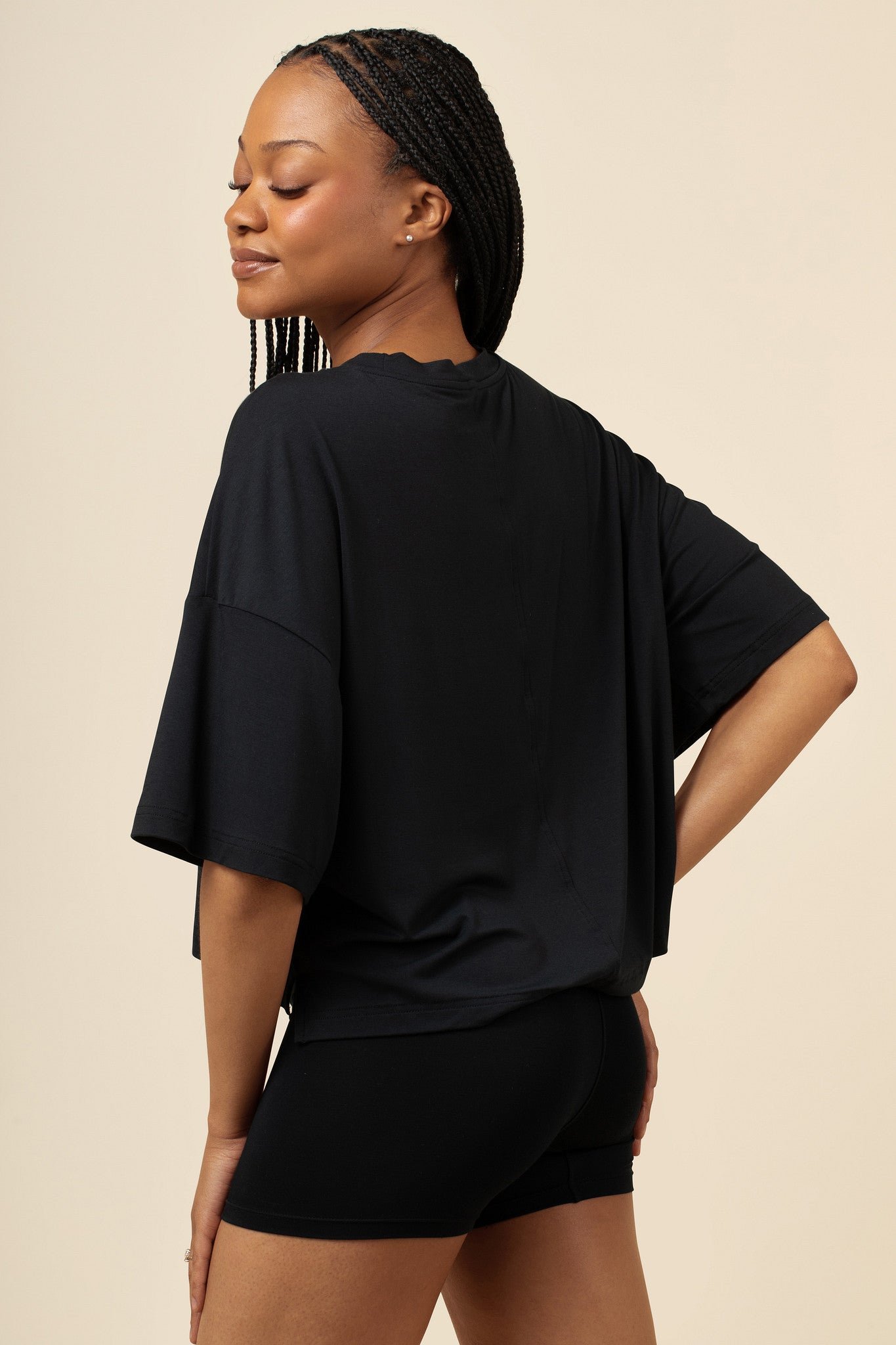 Back side of model wearing the Women's Boxer in Midnight and matching Tee with one hand on hip 
